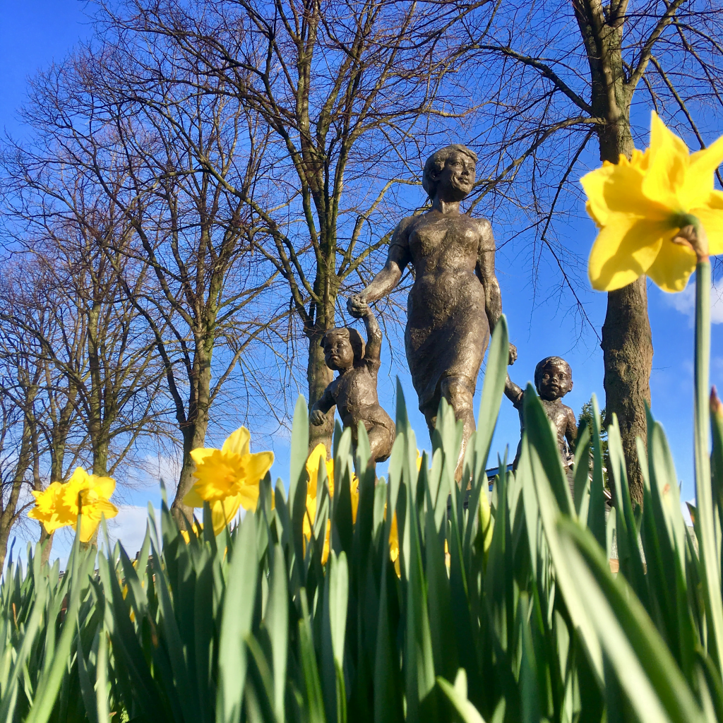 bronzen beeld met bomen en bloemen